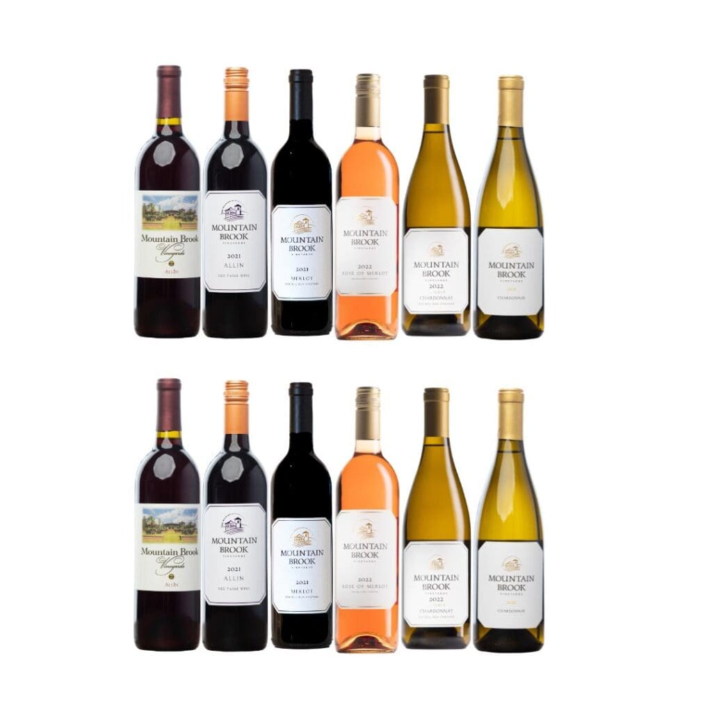 A selection of twelve assorted wine bottles, including red, rosé, and white varieties, arranged in two rows.