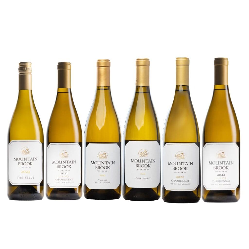 Six bottles of Mountain Brook white wine lined up in a row with white labels facing forward.